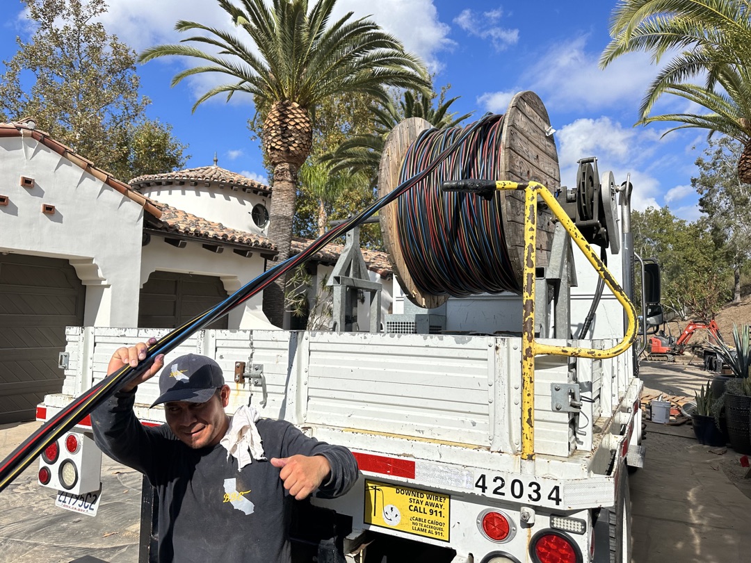 BBE electrician with cable reel at a luxury residential estate in Los Angeles